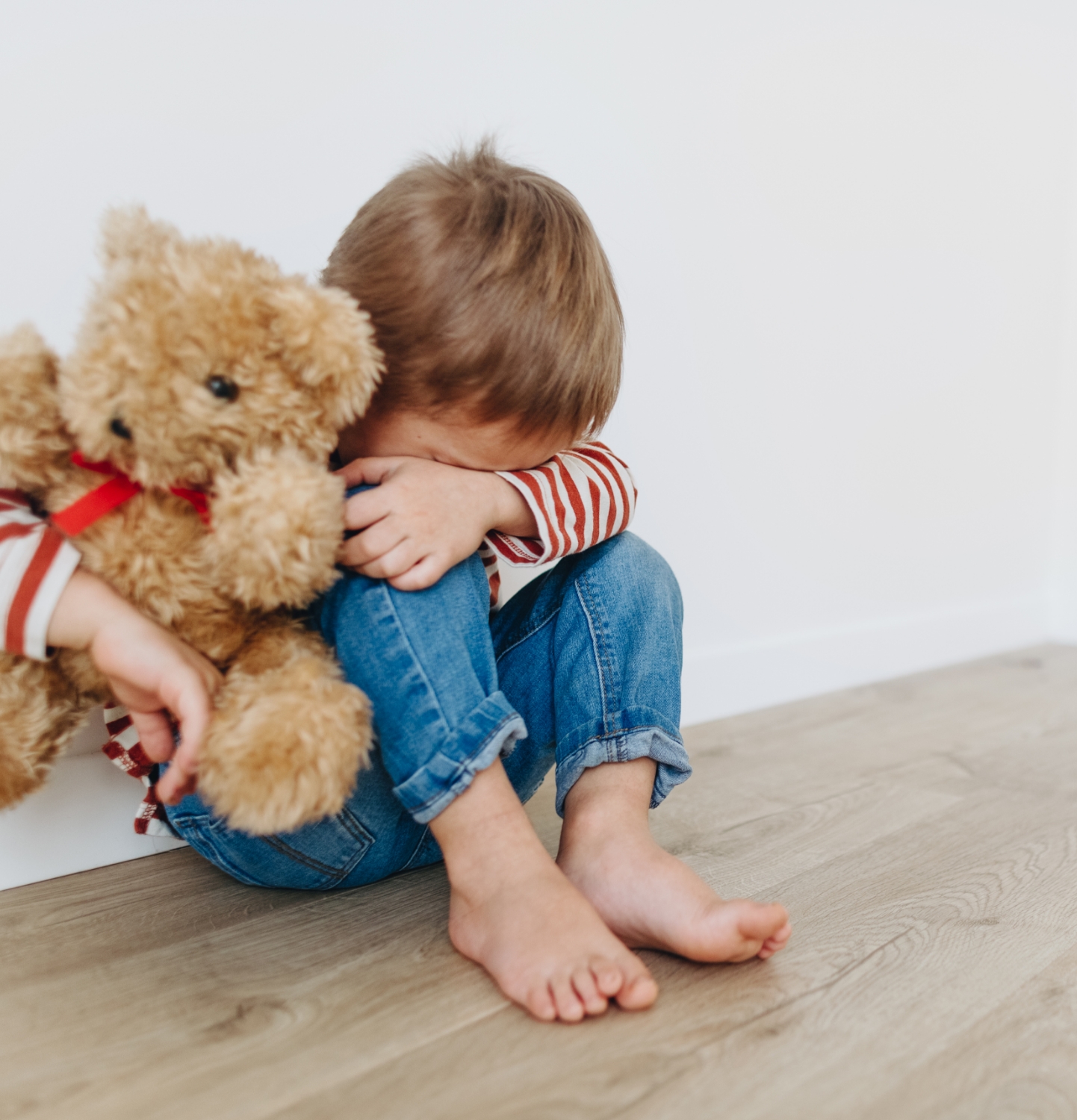 Crying child holding teddy bear